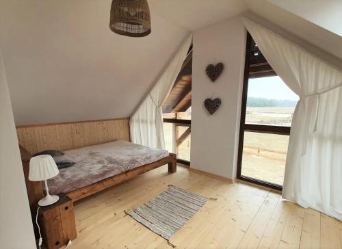 a bedroom with a bed and a large window at Domek na Kaszubach 34-1 - Ostoja Bukowo in Borowy Młyn