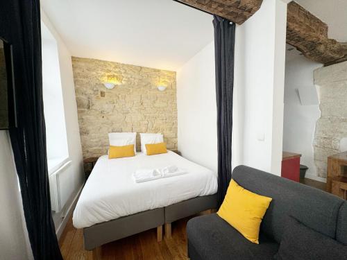 une petite chambre avec un lit et une chaise dans l'établissement Suite Du Lion/AC Historic Flat, Marais, 4-5 Guests, à Paris
