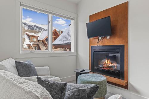 a living room with a fireplace and a tv at Elevated Penthouse Condo managed by Little Sister Getaways in Canmore