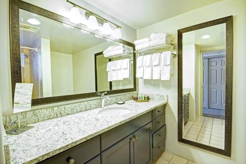 a bathroom with a sink and a large mirror at Starr Pass Golf Suites in Tucson