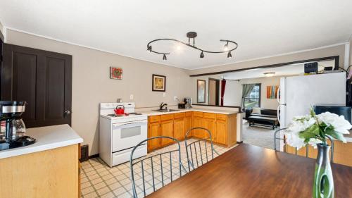 a kitchen with a white refrigerator and a table at Red Hibiscus House - 3 Blocks from Lake Pepin in Lake City