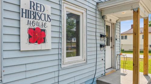 a house with a red infectious house sign on the door at Red Hibiscus House - 3 Blocks from Lake Pepin in Lake City