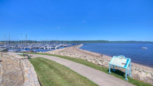 a blue bench next to a marina with boats at Fire Lily Apartment - 3 Blocks from Lake Pepin in Lake City
