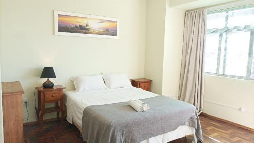 a small bedroom with a bed and a window at Apto 2Q Grande e Espaçoso in Curitiba