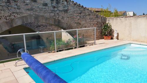 BouillarguesにあるCharmante villaの石壁の前にウォータースライド付きプール