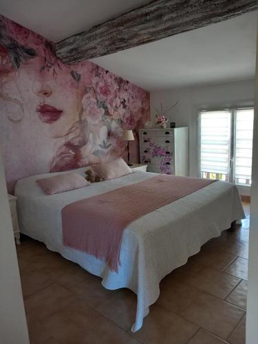 BouillarguesにあるCharmante villaの花の壁のベッドルーム1室(大型ベッド1台付)