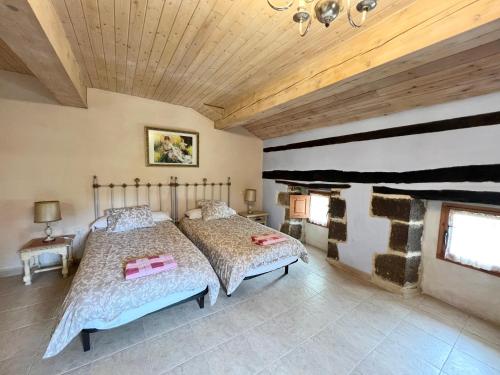 ein Schlafzimmer mit einem Bett und einer Holzdecke in der Unterkunft El Socaire del Trasgo-Complejo de Casas Rurales in Santa Gadea