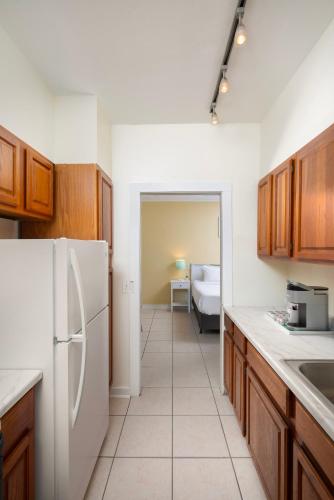 a kitchen with wooden cabinets and a white refrigerator at Southernmost Inn Adult Exclusive in Key West