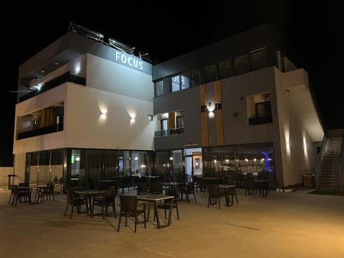 a foroks building with tables and chairs at night at Hotel FOCUS in Prilep
