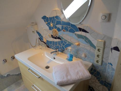 a bathroom with a sink and a mirror at Märchenpension Rotkäppchen und der Wolf in Großwaltersdorf