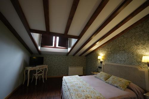 a bedroom with a large bed and a window at Hotel Rural y Restaurante, Rinconcito de Gredos in Cuevas del Valle