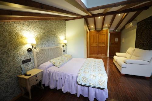 a small bedroom with a bed and a couch at Hotel Rural y Restaurante, Rinconcito de Gredos in Cuevas del Valle