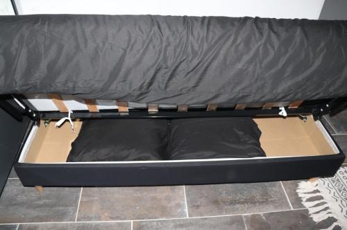 un petit lit avec un drap noir dessus dans l'établissement Agréable studio avec sa terrasse extérieure entièrement aménagé à 5 min de la mer, à Cannes