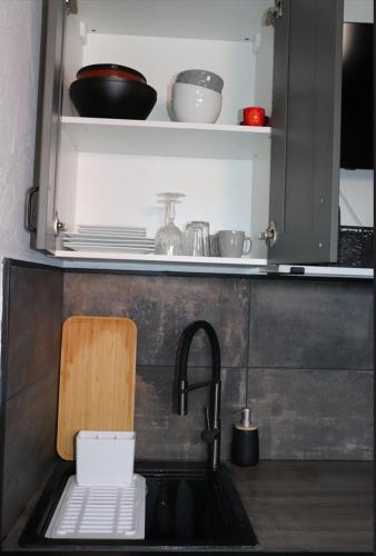 un évier de cuisine avec une planche à découper et un évier dans l'établissement Agréable studio avec sa terrasse extérieure entièrement aménagé à 5 min de la mer, à Cannes