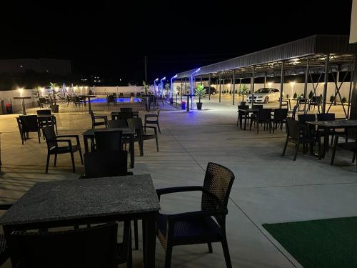 an empty patio with tables and chairs at night at Hotel FOCUS in Prilep