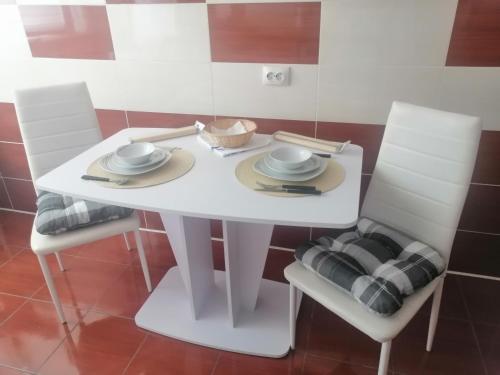 a white dining room table with two white chairs at Medeea Studio in Alba Iulia