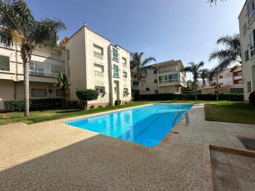 a swimming pool in front of a building at Très Bel Appartement familial sur Rabat Temara PLAGES avec Piscines in El Harhoura