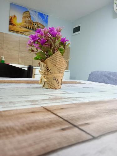a vase with purple flowers sitting on a table at Serenita Stone House in Becici