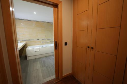 a bathroom with a tub and a toilet and a sink at Hotel Rural y Restaurante, Rinconcito de Gredos in Cuevas del Valle