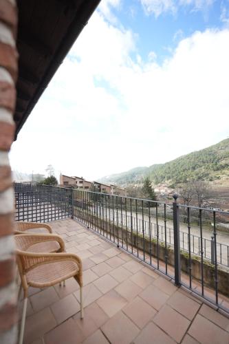 a balcony with chairs and a view of the water at Hotel Rural y Restaurante, Rinconcito de Gredos in Cuevas del Valle