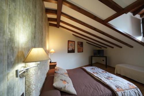a bedroom with a bed in a room with wooden ceilings at Hotel Rural y Restaurante, Rinconcito de Gredos in Cuevas del Valle