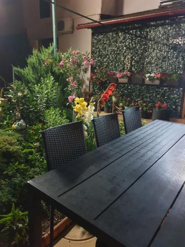 stół i krzesła w ogrodzie z kwiatami w obiekcie Casa Mary w mieście Costinesti