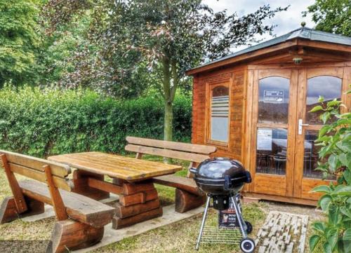 a wooden cabin with a picnic table and a grill at Blockhaus Barbarossa - Annie in Rottleben