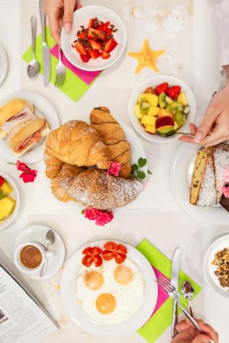 una mesa cubierta con platos de desayuno en Hotel Trieste Mare, en Lignano Sabbiadoro