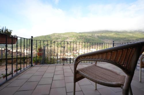 a bench sitting on a balcony with a view at Hotel Rural y Restaurante, Rinconcito de Gredos in Cuevas del Valle