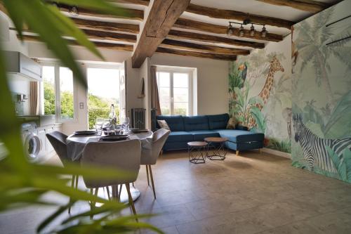 un salon avec un canapé bleu et une table dans l'établissement Le Toucan, à Saint-Aignan