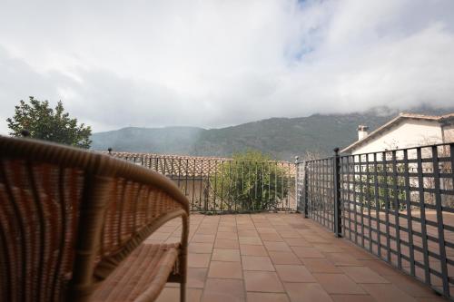 a bench sitting on a balcony with a fence at Hotel Rural y Restaurante, Rinconcito de Gredos in Cuevas del Valle