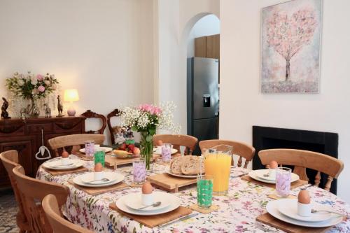 a dining room table with a floral table cloth at The Pink Door Seaside Holiday Home in Ventnor