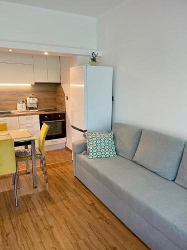 ein Wohnzimmer mit Couch und Tisch und eine Küche in der Unterkunft Varna city Park Apartament in Warna