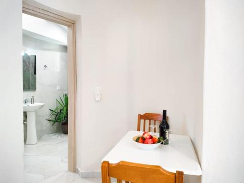 a table with a bowl of fruit and a bottle of wine at Classy Louvis House in Akti Salonikiou