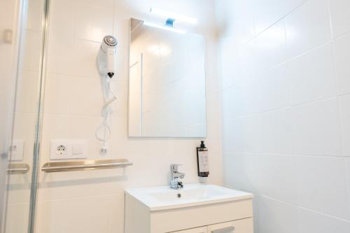 a white bathroom with a sink and a mirror at encanto rural en arce by urbanhosting in Arce