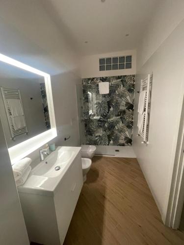 a bathroom with a sink and a toilet and a mirror at Casa Maiorino in Torre del Greco