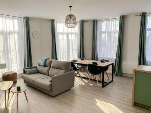 un salon avec un canapé et une table dans l'établissement Appartement lumineux et cosy, à Annay