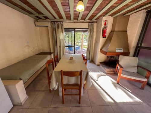 a room with a table and a bed and a fireplace at Cabañas Del Sol in Valle Grande