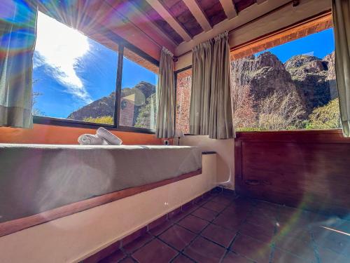 a bathroom with a tub and a large window at Cabañas Del Sol in Valle Grande