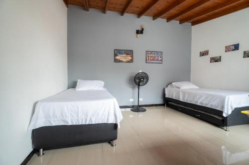 a bedroom with two beds and a fan at 5STARHOMES - Estilo y confort en Laureles in Medellín