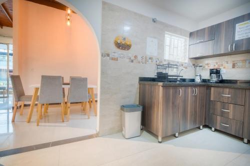 a kitchen with wooden cabinets and a table with chairs at 5STARHOMES - Estilo y confort en Laureles in Medellín