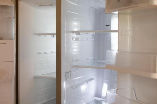 un réfrigérateur blanc vide avec sa porte ouverte dans l'établissement Spacious 3BR Home for 10 Guests Near Downtown Theme Parks & AT&T Stadium 510, à Grand Prairie