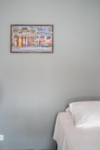 a picture hanging on a wall next to a bed at 5STARHOMES - Estilo y confort en Laureles in Medellín