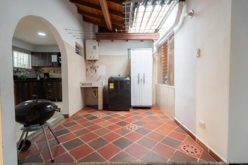 a kitchen with a tile floor and a black refrigerator at 5STARHOMES - Estilo y confort en Laureles in Medellín