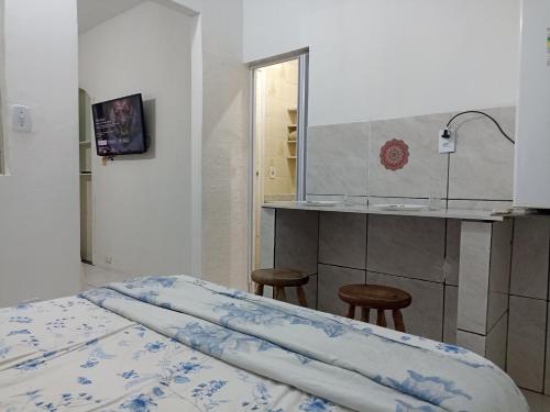a bedroom with a bed and a counter and a kitchen at Refúgio de Piratininga 104 in Niterói