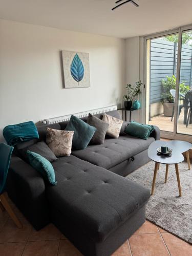 un salon avec un canapé et une table dans l'établissement Au calme dans maison en rez de jardin à 2,2 kms du Groupama stadium et salle LDLC Arena, à Meyzieu