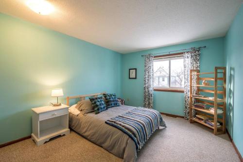 a bedroom with blue walls and a bed and a window at Dream House, a Creative Escape in the Heart of Powderhorn in Minneapolis