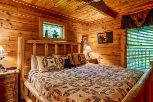 a bedroom with a bed in a log cabin at Miss BeeHaven in Sevierville
