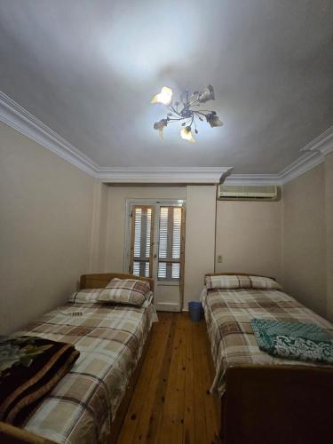 a bedroom with two beds and a ceiling fan at Villa Apartment Nile View in City Center in Cairo