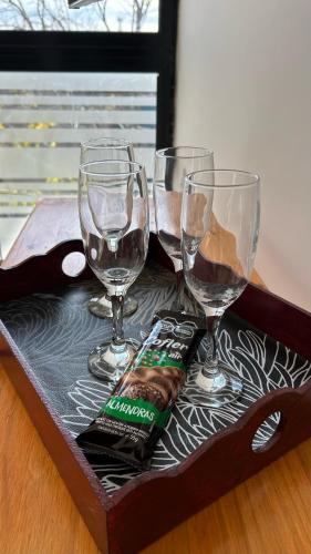 a tray with three wine glasses and a bottle of alcohol at Temporarios Alfonso in Santa Fe